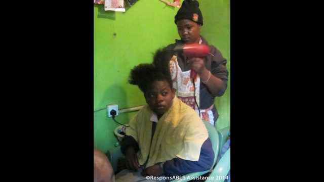 A girl practises cutting and blow drying the hair of a fellow student