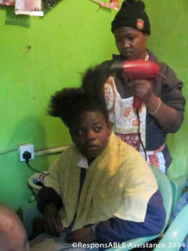 A girl practises cutting and blow drying the hair of a fellow student