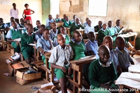 A classroom where three students have to sit closely together on each small and narrow bench table