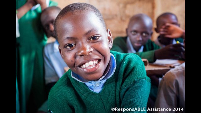 A boy smiles broadly at the camera
