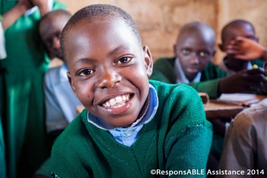 A boy smiles broadly at the camera