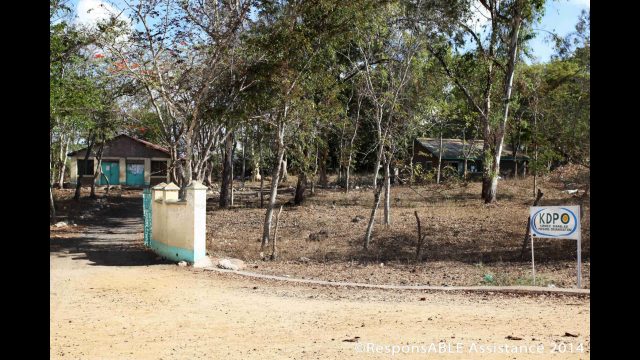 The entrance to the Kibwezi Disabled Peoples Organisation (KDPO), where trees surround the small buildings which are set back off a dirt road