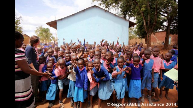 A large group of young children are all excited as they pose for the camera