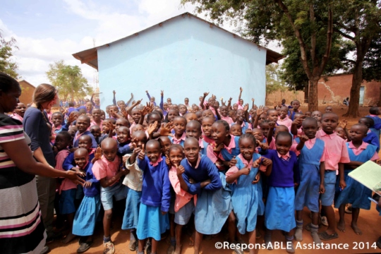 A large group of young children are all excited as they pose for the camera